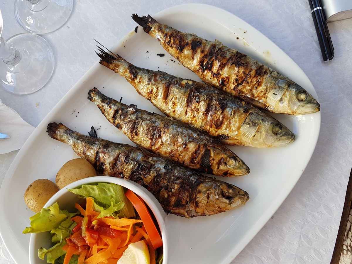 Ovos moles egg confections in shell and fish shapes on a ceramic plate in Aveiro