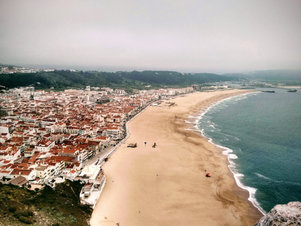 Colourful beach tents and fishing boats on Nazaré beach on the Silver Coast